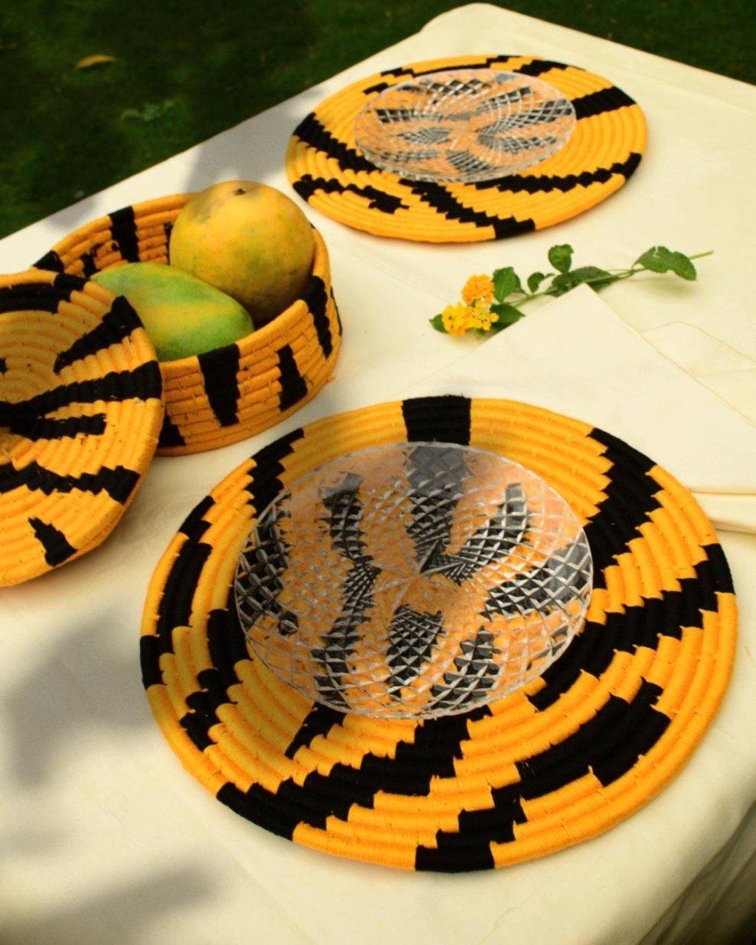 Tiger print Sabai placemats and fruit basket in a table setting with glass plates and mangoes