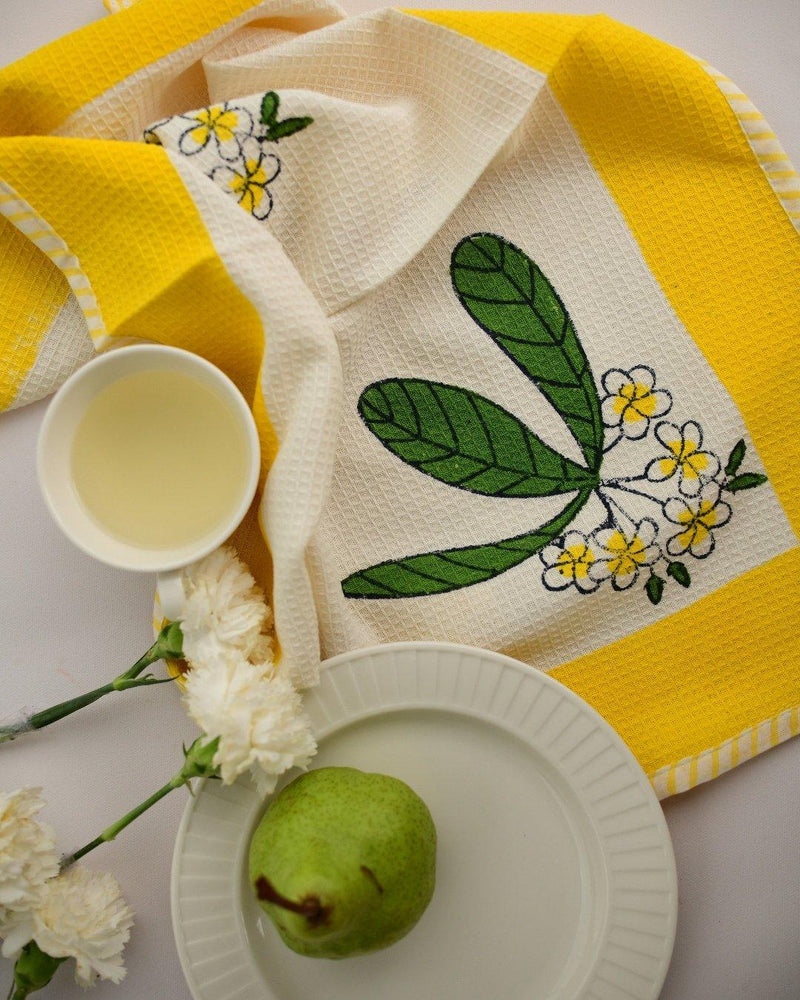 Tea towel with block printed frangipani or champa flowers in yellow and green