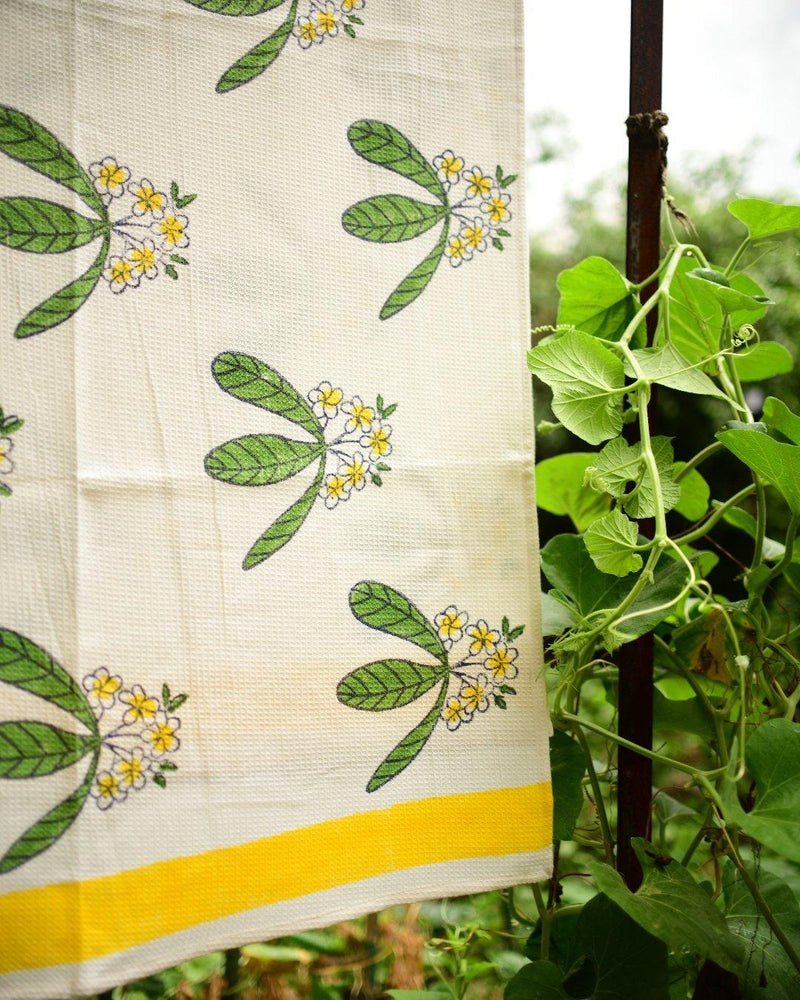 Block printed cotton waffle towel with frangipani or champa flowers in yellow and green