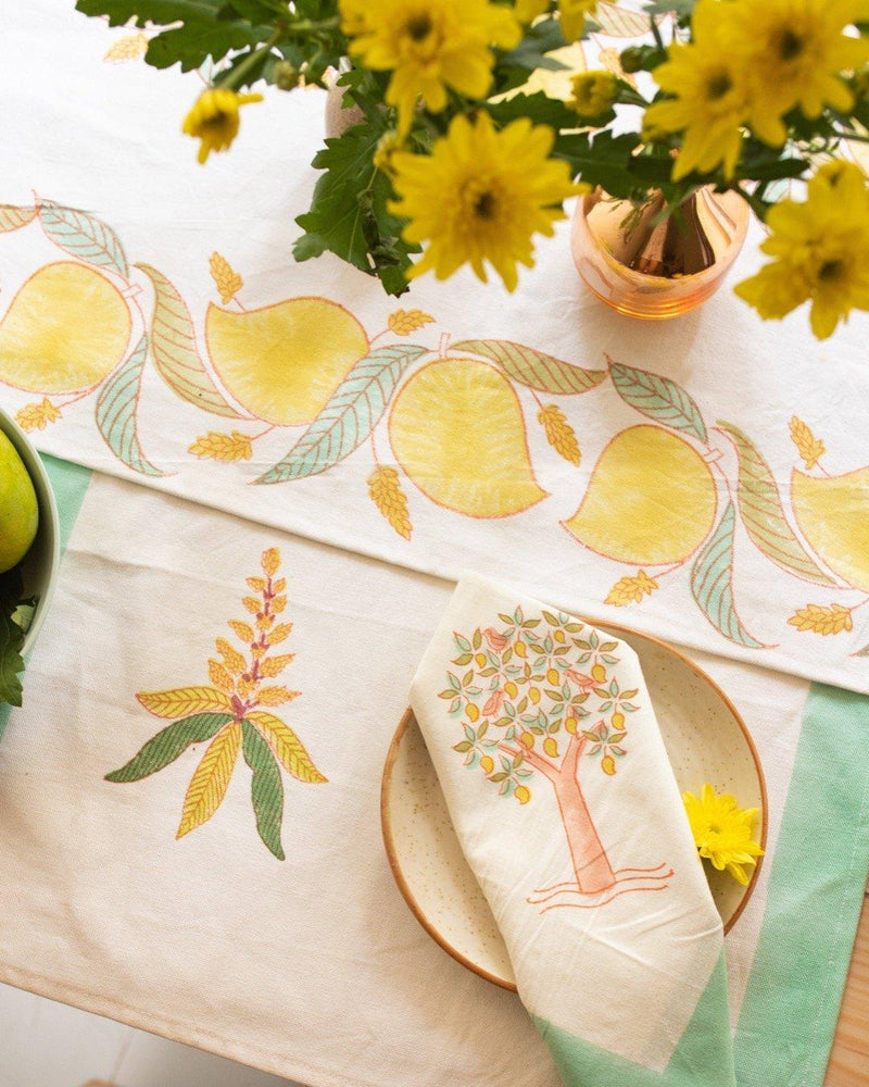 A table setting with Block printed placemats and napkins with motifs of mango blossoms and trees, made of canvas and cotton