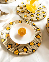 Leopard print Sabai grass placemats in a table setting with an orange and some juice on top