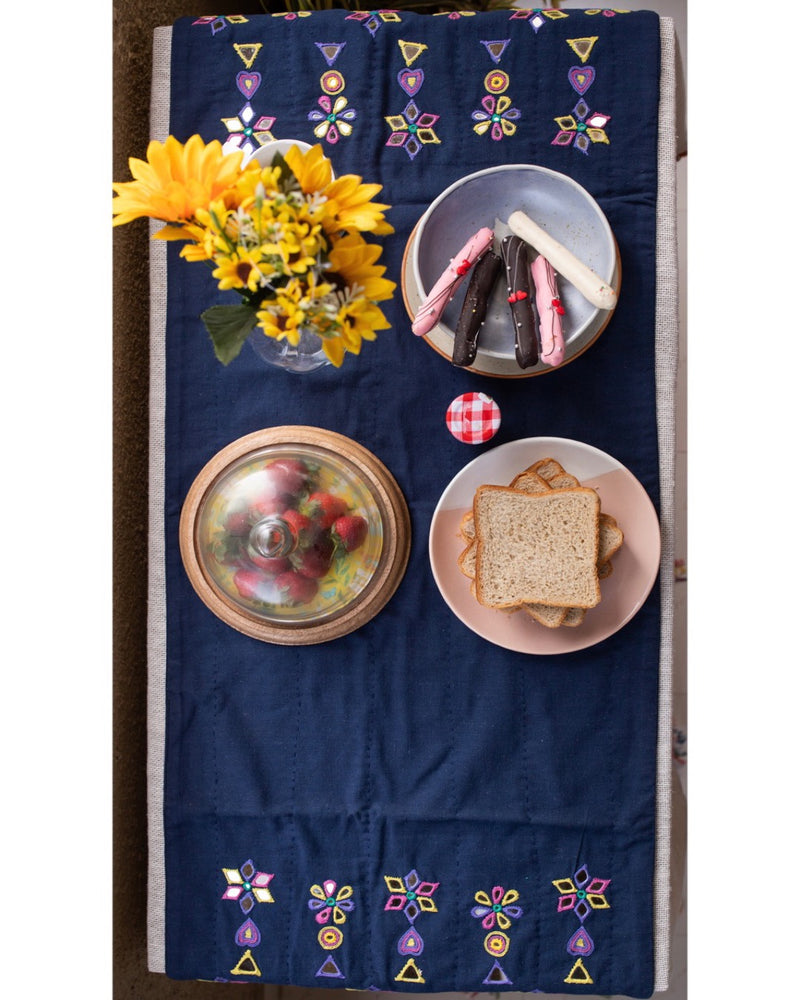 Food and flowers on indigo table runner full view