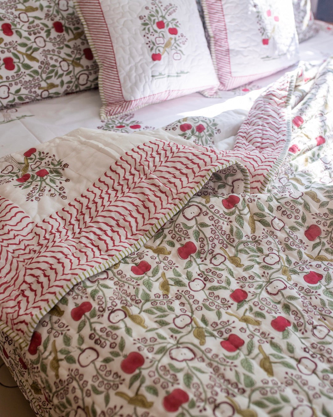 Apple orchard themed quilt on bed