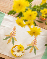 A table setting with Block printed placemats and napkins with motifs of mango blossoms and trees, made of canvas and cotton