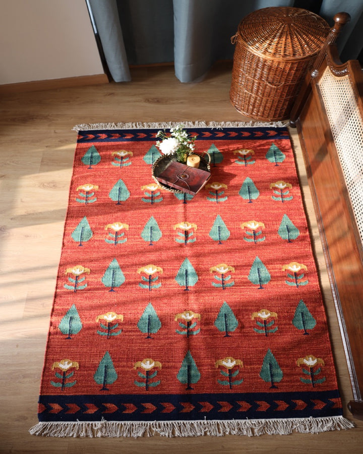 Basket on red rug with flower and tree design 