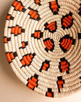 Leopard print handwoven Sabai grass wall plate or basket with orange and black threadwork